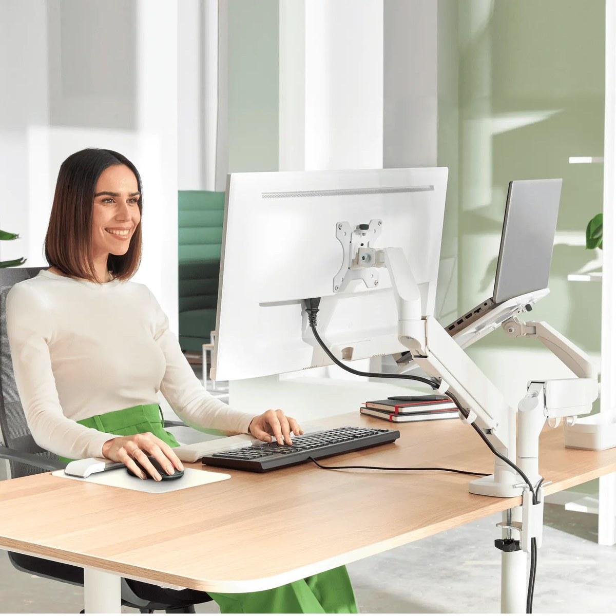 Braço articulado de secretária para monitor e portátil Leitz Ergo em uso